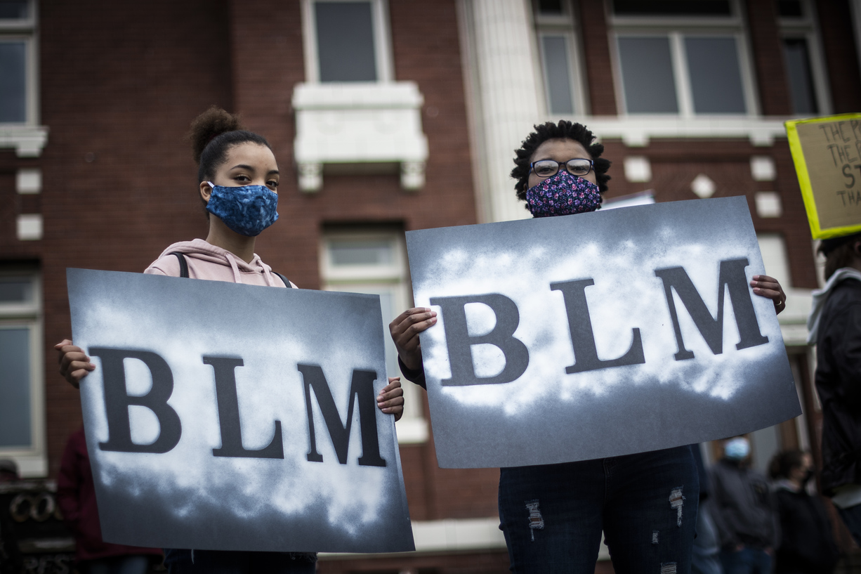 Two young people holding BLM signs