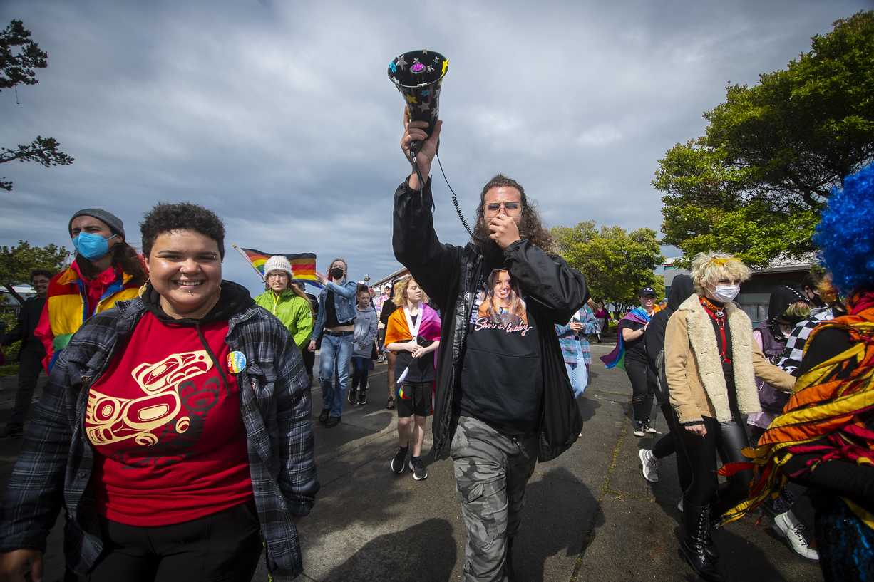 Group of people marching through town while one speaks into a bullhorn