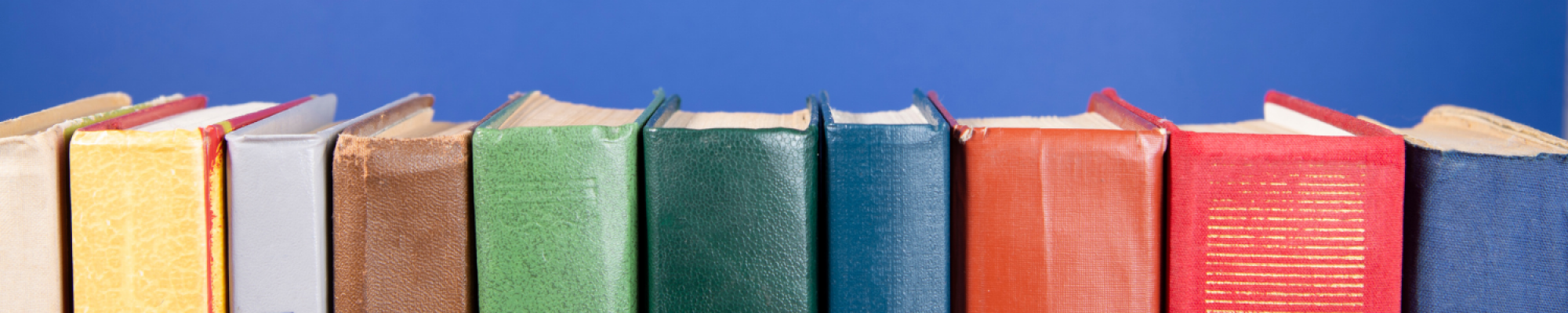Row of different colored books on a dark blue background
