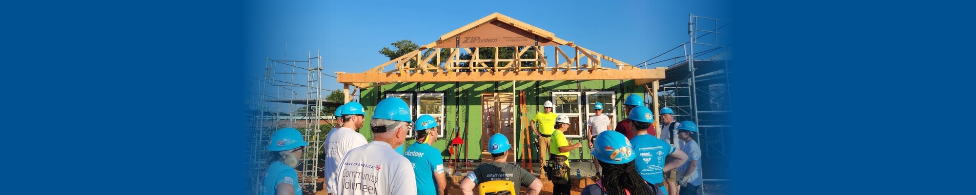 A group of volunteers in front of a house under construction