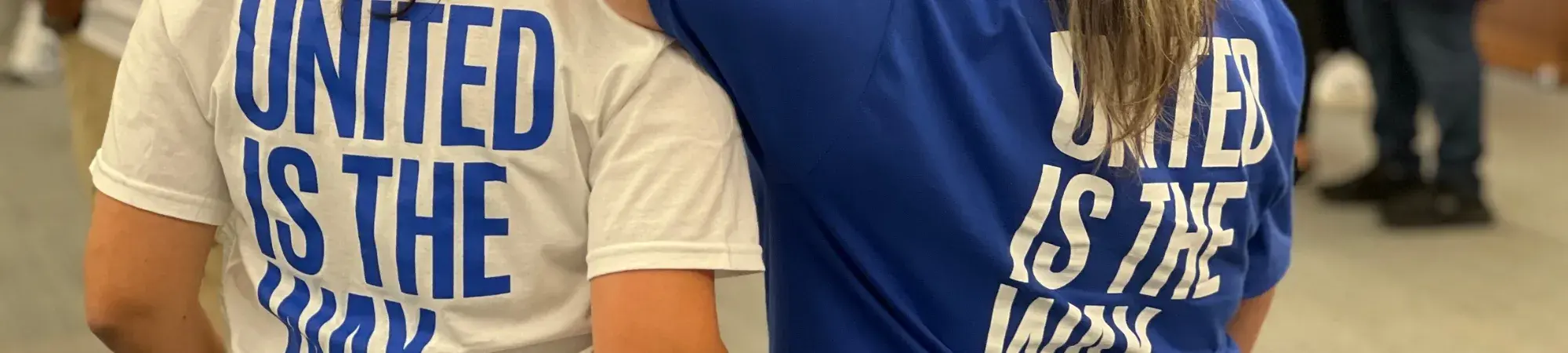 Writing on the back of matching white and blue t-shirts reading "United is the Way."