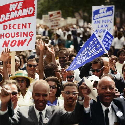 Historical photo of a large group of mostly black individuals at the March on Washington holding signs with various demands 