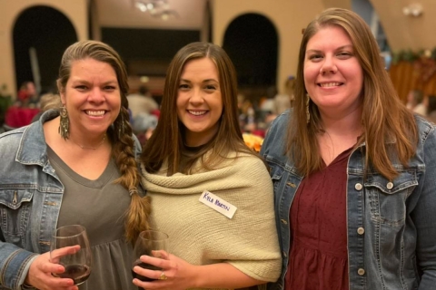 Three women smiling at a cocktail party