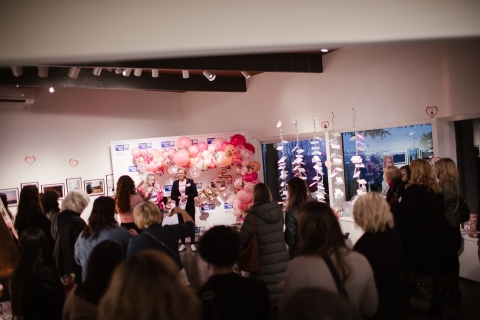 two women speaking in front of a crowd