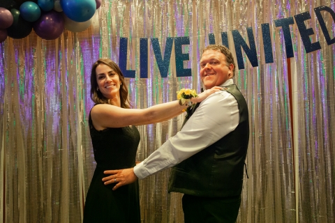 Smiling people in front of sparkly backdrop