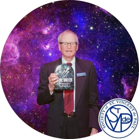 man holding an award in front of a space background