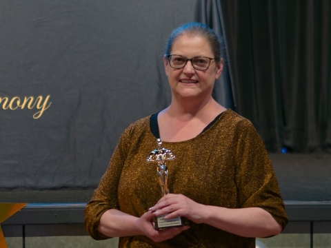 smiling woman holding award