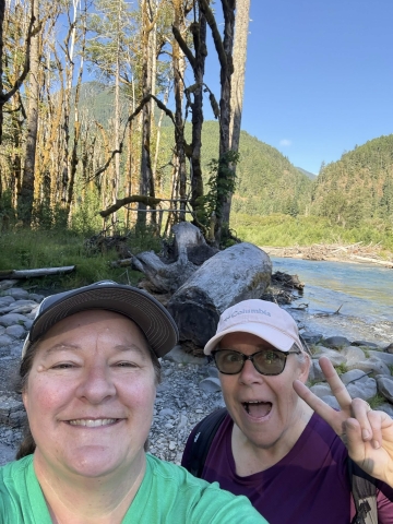 Two women smiling while on a hike