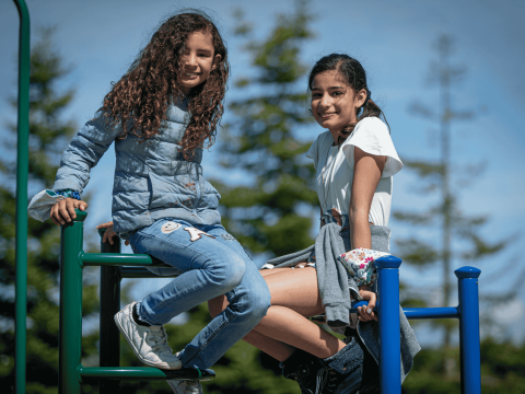 Two young girls on a jungle gym