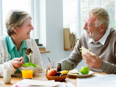 A smiling couple having a meal at home