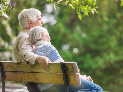 elderly couple sitting on a park bench