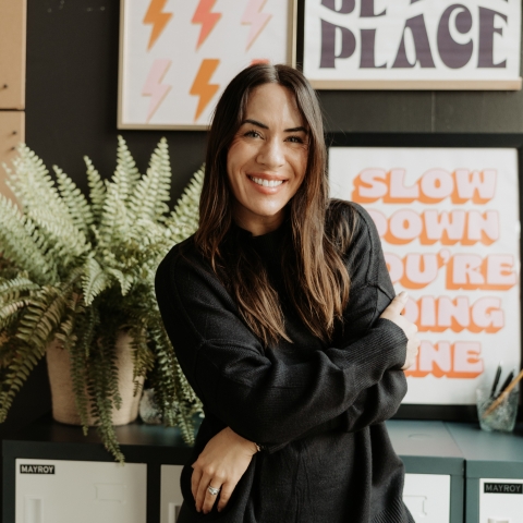Smiling woman in front of posters with motivational phrases