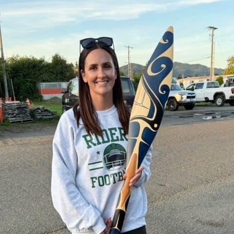 smiling woman holding canoe oar