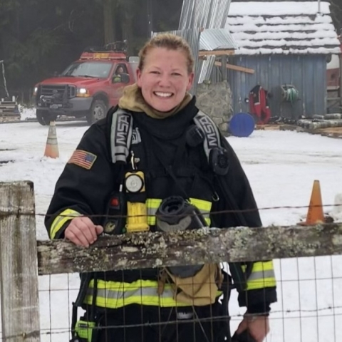smiling female firefighter in snow
