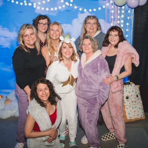group of smiling women in fuzzy pajamas