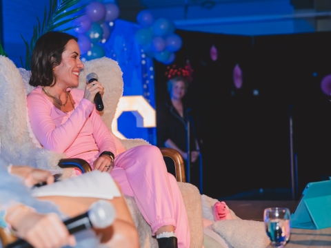 smiling woman with microphone on stage
