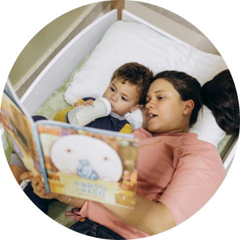woman reading to young son in bed