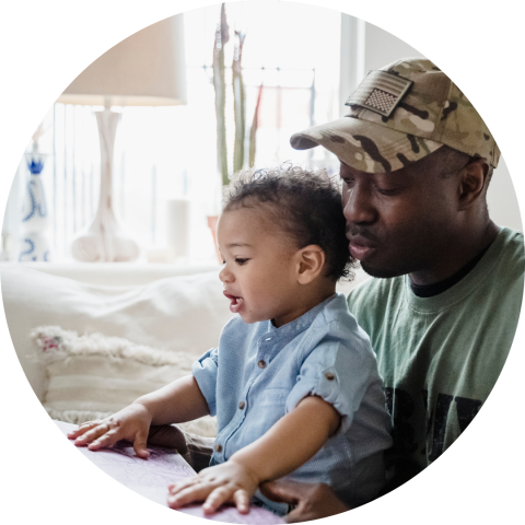 dad in military cap reading to young son