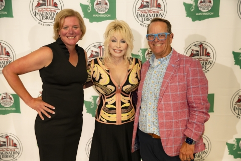 Dolly Parton hugging a man and woman
