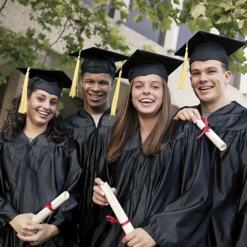 4 young graduates in caps and gowns