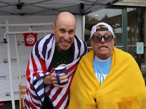 two men wrapped in towels who look cold
