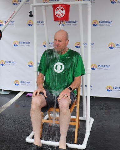 man sitting under a bucket dunk apparatus