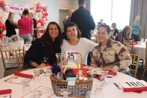smiling women at a table at an event