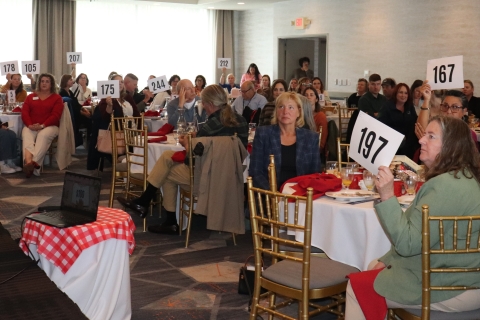 room full of people holding up bid numbers