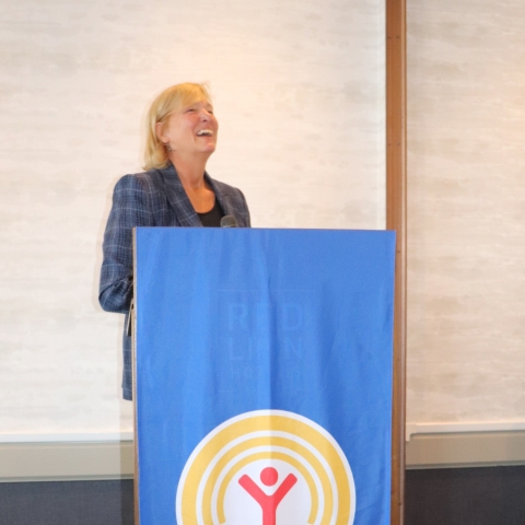 laughing woman at a podium